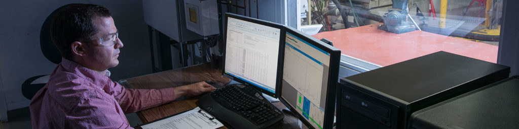 Rotoflow engineer sitting in front of a laptop computer screen to view the results of a spin test on a turboexpander