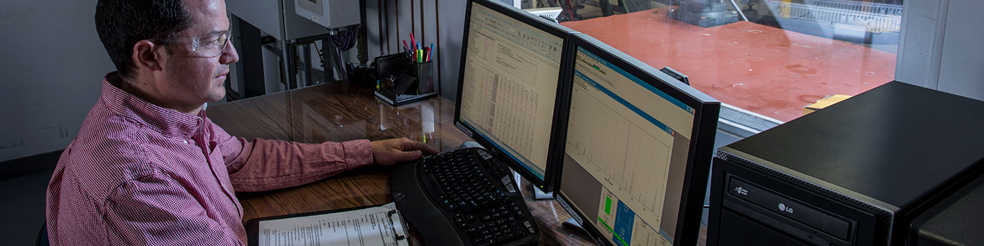 Rotoflow engineer sitting in front of a laptop computer screen to view the results of a spin test on a turboexpander