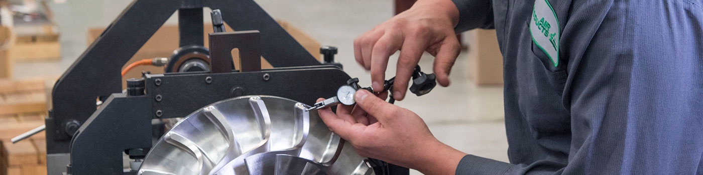 Technician performing a quality check on a turboexpander part.