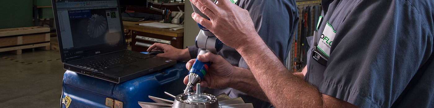 Two Rotoflow technicians in the shop, using a laser scanner to inspect an impeller prior to assembly