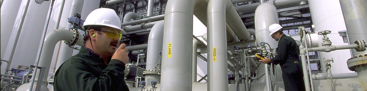 Two workers wearing hard hats providing customer support to an LNG plant using Rotoflow turboexpander equipment